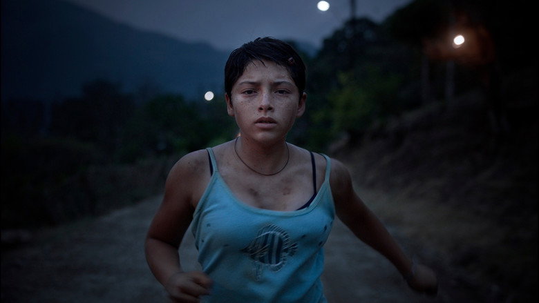 Three young girls sit on a dirt road, their faces smudged with dust, staring directly at the camera with a mix of curiosity and wariness.