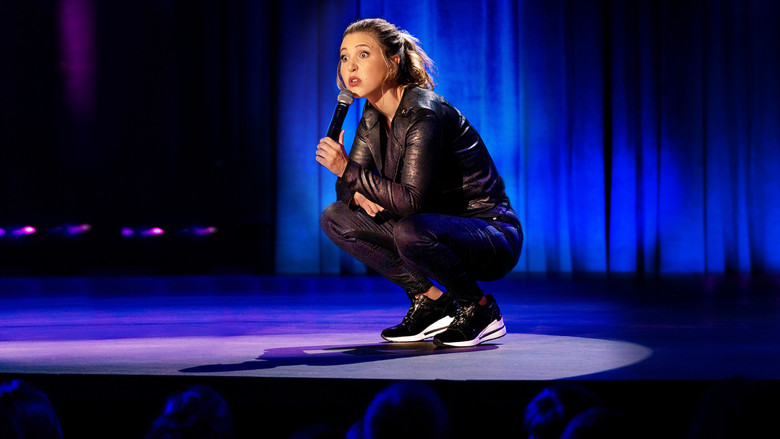 Tomlinson mid-performance, her hands gesturing as she delivers a punchline