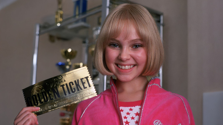 Willy Wonka standing at the gates of his factory