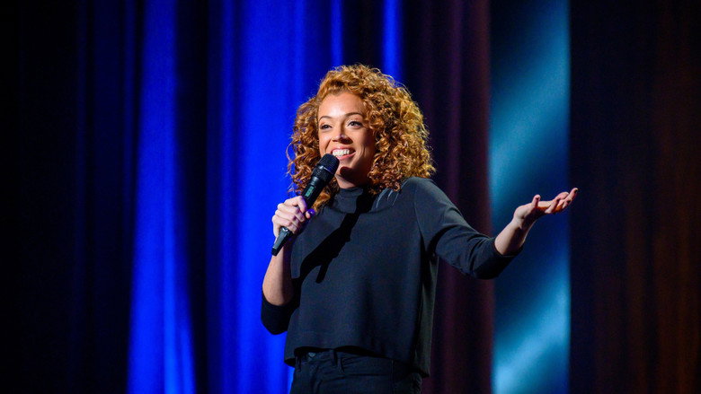 Michelle Wolf on stage, mid-gesture, her face lit with the kind of smirk that suggests she’s about to dismantle something sacred.