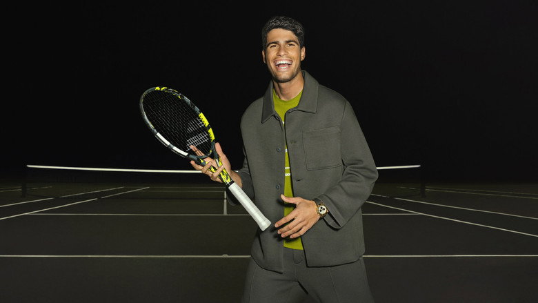 Alcaraz mid-swing, sweat flying, the weight of expectation visible in his clenched jaw