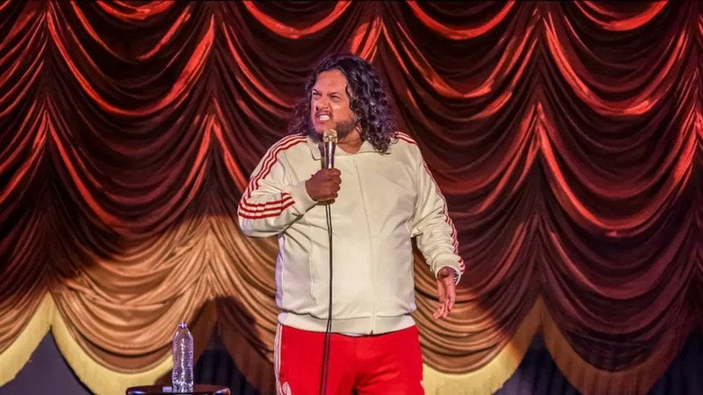 Felipe Esparza mid-laugh on stage, his face contorted in exaggerated disbelief, the black-and-white aesthetic giving the moment a timeless, almost cinematic weight.