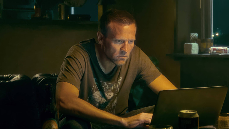 A shadowy, silhouetted figure standing against a harsh, industrial cityscape at night