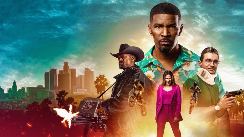 A neon-lit Los Angeles street at night, with Bud Jablonski (Jamie Foxx) crouched behind a car, stake in hand, scanning the shadows for vampires.