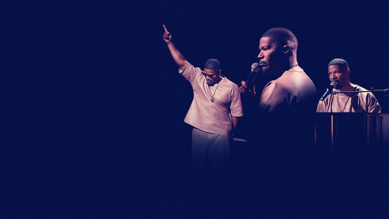 Jamie Foxx on stage, bathed in warm light, mid-performance with a microphone in hand