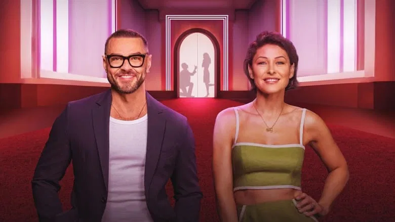 Two contestants in the pods, separated by a wall, their hands pressed against the same surface but not touching